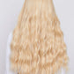 girl wearing long wavy bleach blonde wig