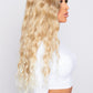 synthetic blonde curly hair wig from pbeauty hair being worn by model wearing a white top