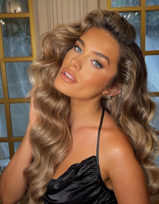 The romantic wavy hairstyle features soft, voluminous waves cascading in loose curls, creating an elegant and glamorous look perfect for special events or red carpets, adding texture and volume.