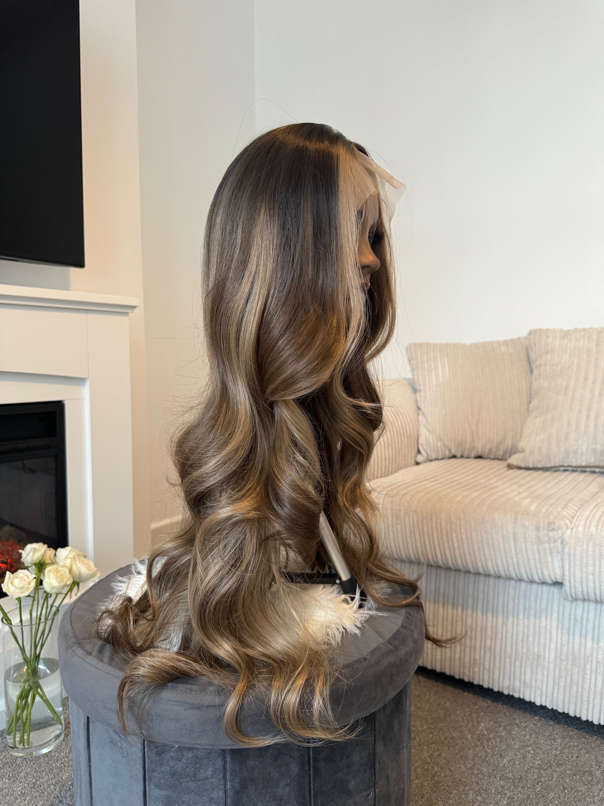 Product Side view of a balayage wig with natural waves, highlighting the seamless lace front and realistic texture