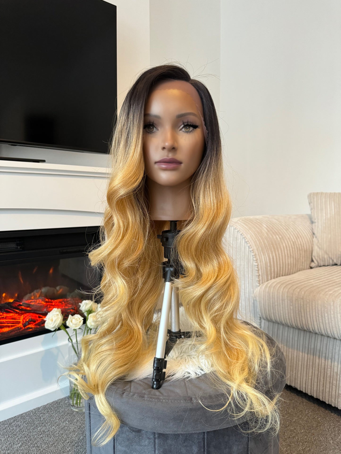 product Close-up of a synthetic honey blonde wig with a lace front, highlighting the rich color and realistic hairline