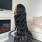 Side view of the 28-inch black synthetic hair wig with wavy texture and long length