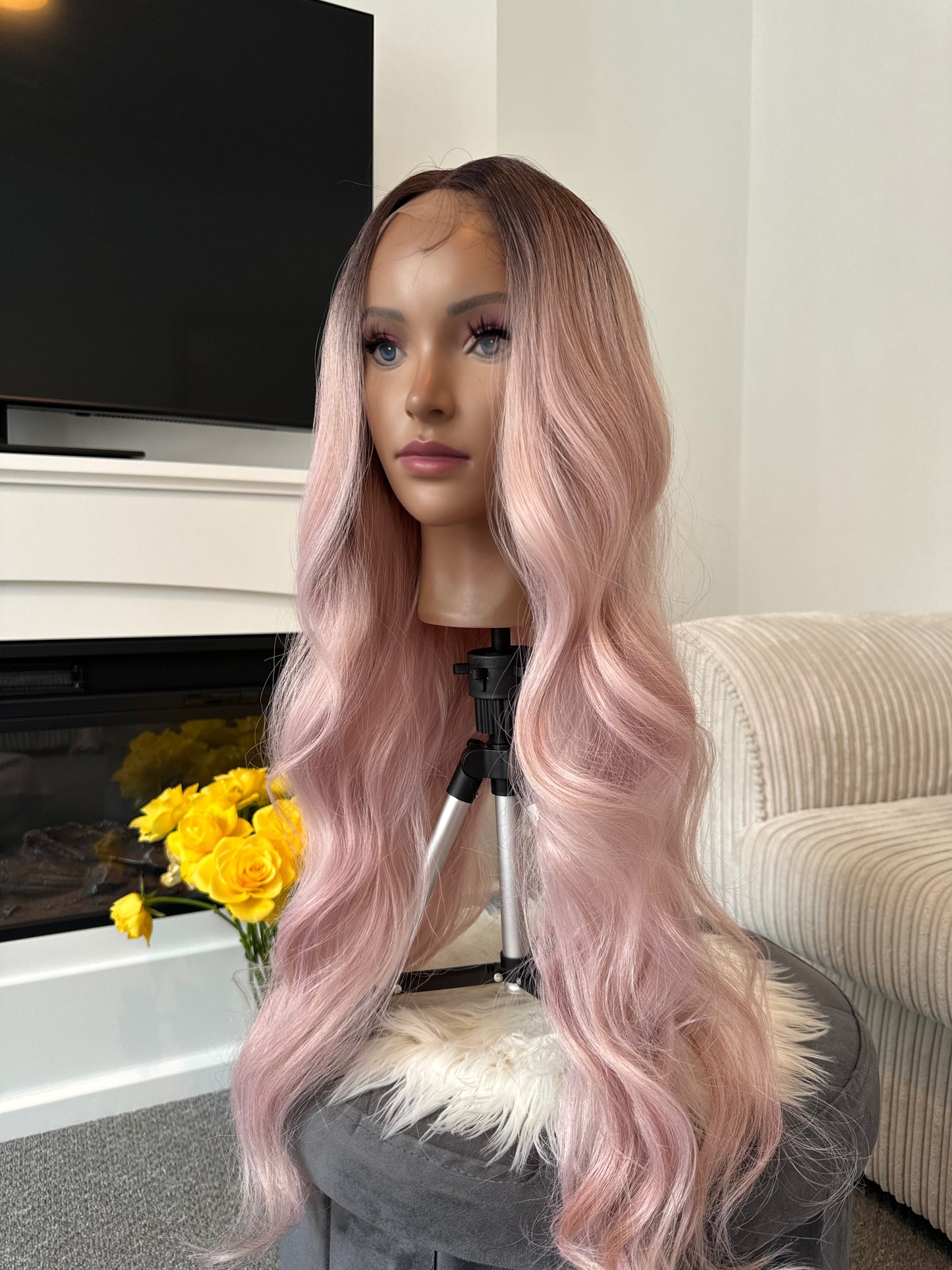 Side view of a wavy pink wig with a lace front, showcasing the soft waves and natural finish